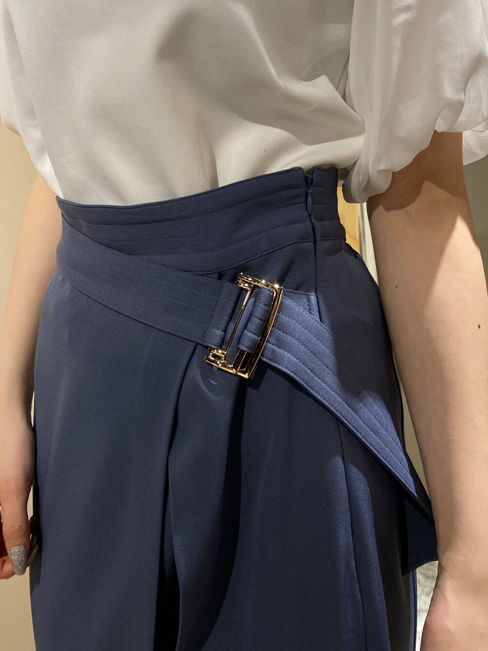 ホワイト系のニット/セーター、ブルー系のスカート、ホワイト系のパンプスを着用したレディースの春コーディネートの6枚目の写真