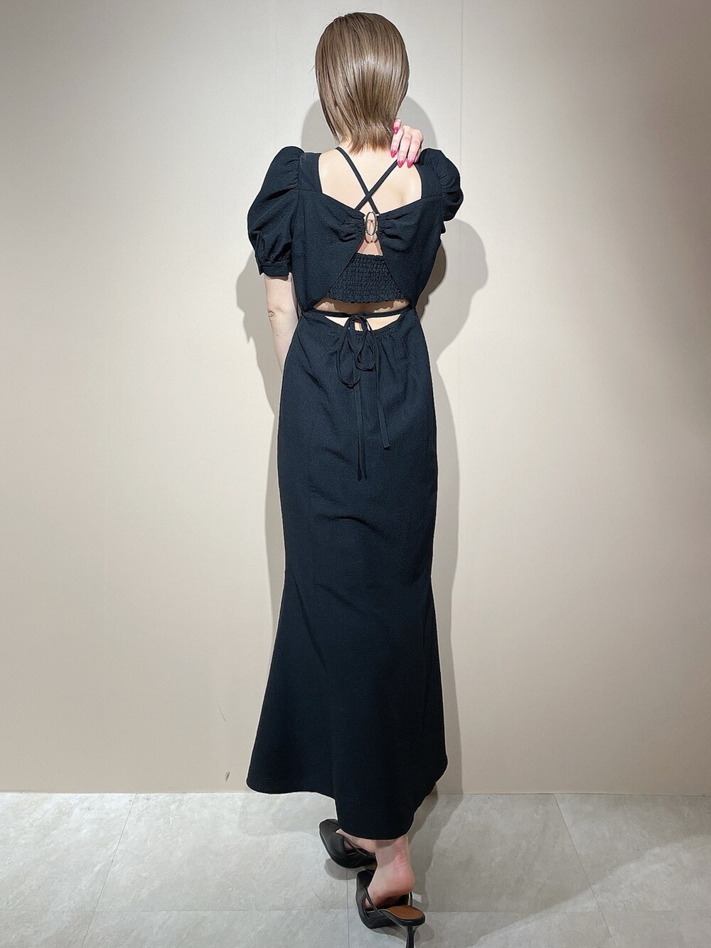 ブラック系のワンピース、ブラック系のパンプスを着用したレディースの春コーディネートの2枚目の写真