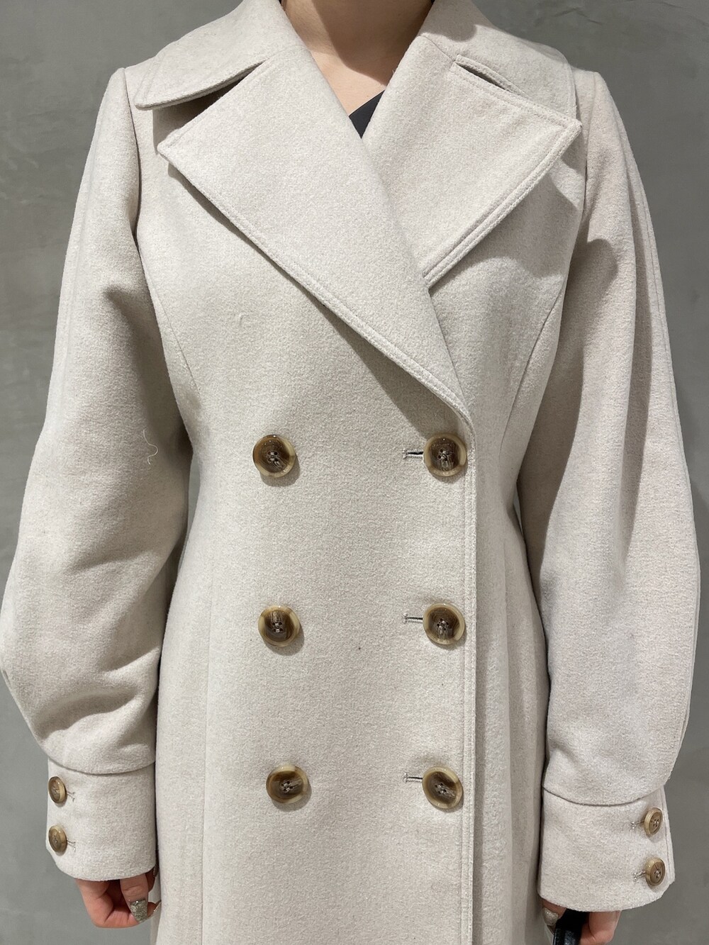 ベージュ系のその他アウター、グレー系のワンピース、ブラック系のハンドバッグを着用したレディースの冬コーディネートの7枚目の写真