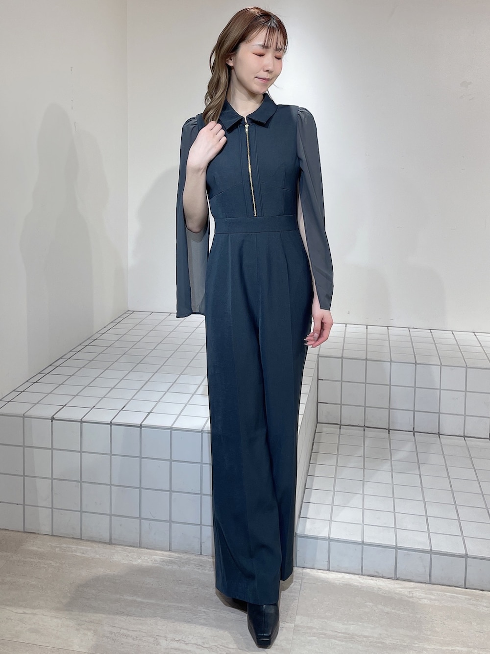 グレー系のワンピース、ブラック系のブーツを着用したレディースの冬コーディネートの2枚目の写真