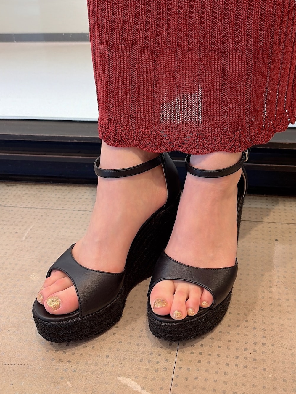 レッド系のワンピース、ブラウン系のハンドバッグ、ブラック系のサンダルを着用したレディースの夏コーディネートの6枚目の写真