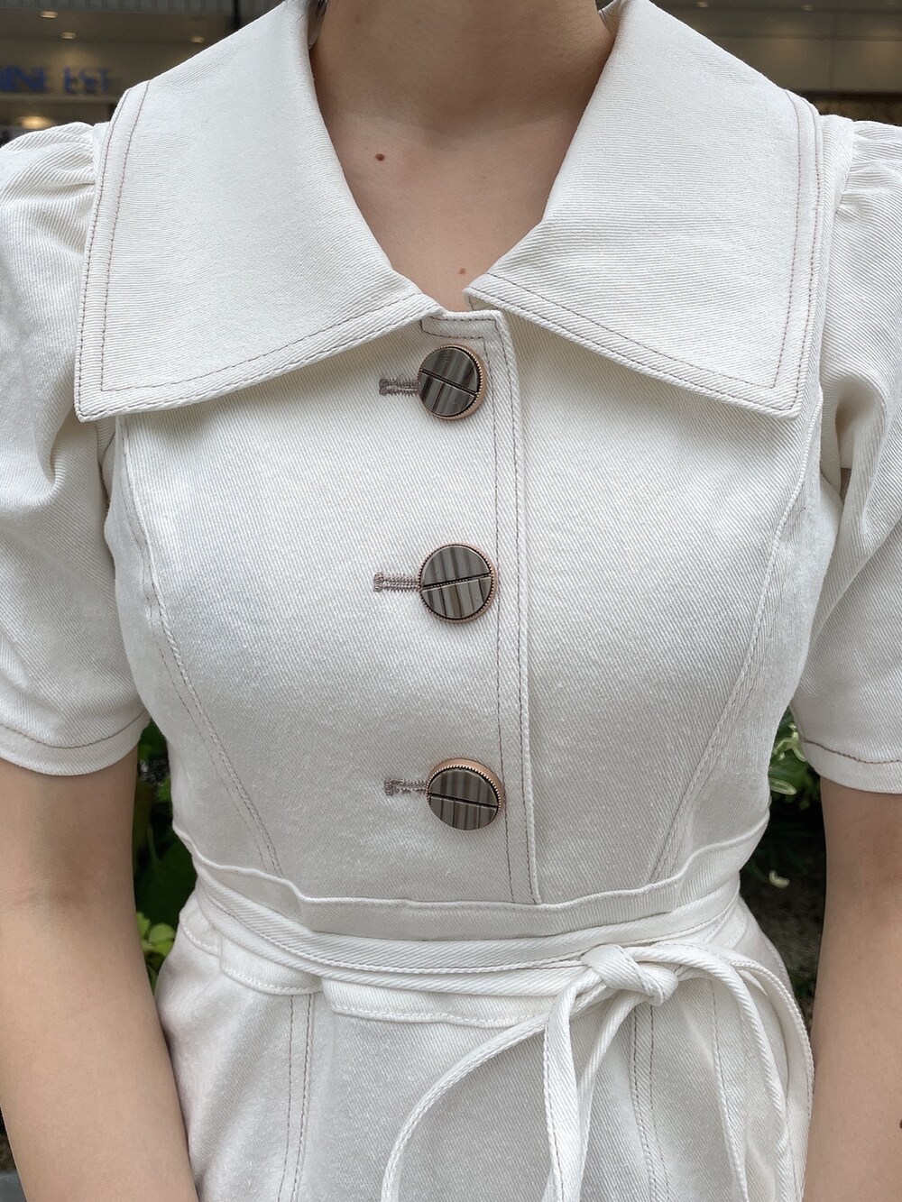 ホワイト系のワンピース、ホワイト系のハンドバッグ、ベージュ系のサンダルを着用したレディースの夏コーディネートの6枚目の写真