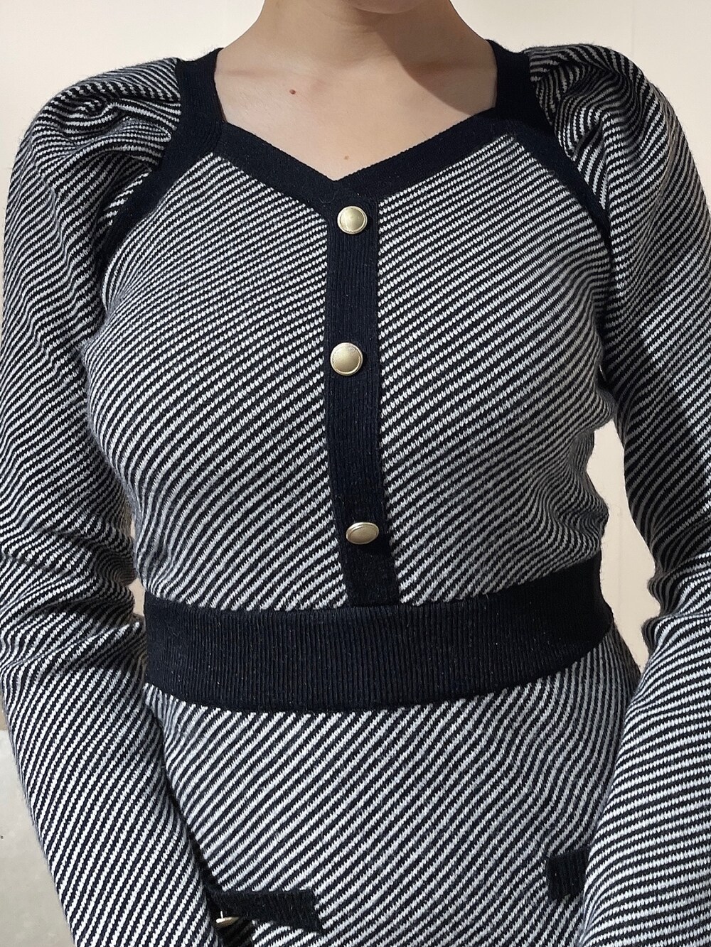 ブラック系のワンピース、ブラック系のハンドバッグ、ブラック系のパンプスを着用したレディースの秋コーディネートの5枚目の写真