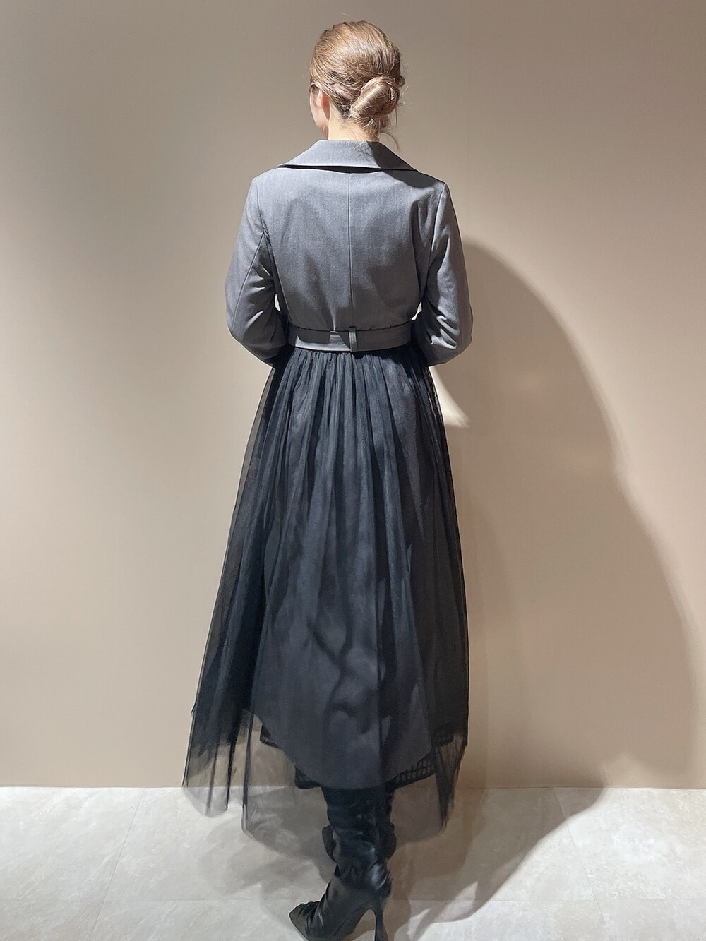 グレー系のトレンチコート、ブラック系のハンドバッグ、ブラック系のブーツを着用したレディースの秋コーディネートの5枚目の写真