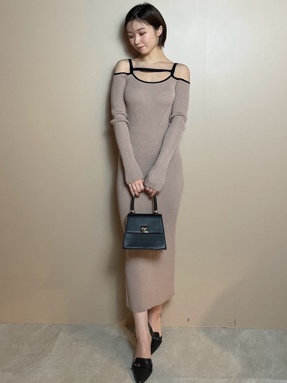 その他のワンピース、ブラック系のハンドバッグ、ブラック系のパンプスを着用したレディースの冬コーディネートの2枚目の写真