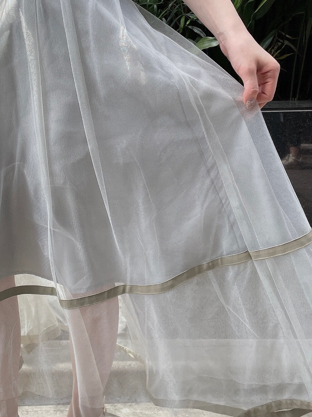 グリーン系のスカート、ホワイト系のサンダル、ホワイト系のTシャツ/カットソーを着用したレディースの春コーディネートの7枚目の写真