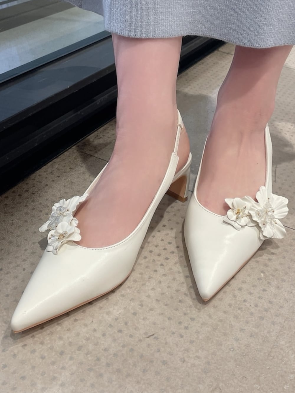 ホワイト系のトレンチコート、ピンク系のショルダーバッグ、オレンジ系のワンピースを着用したレディースの冬コーディネートの10枚目の写真