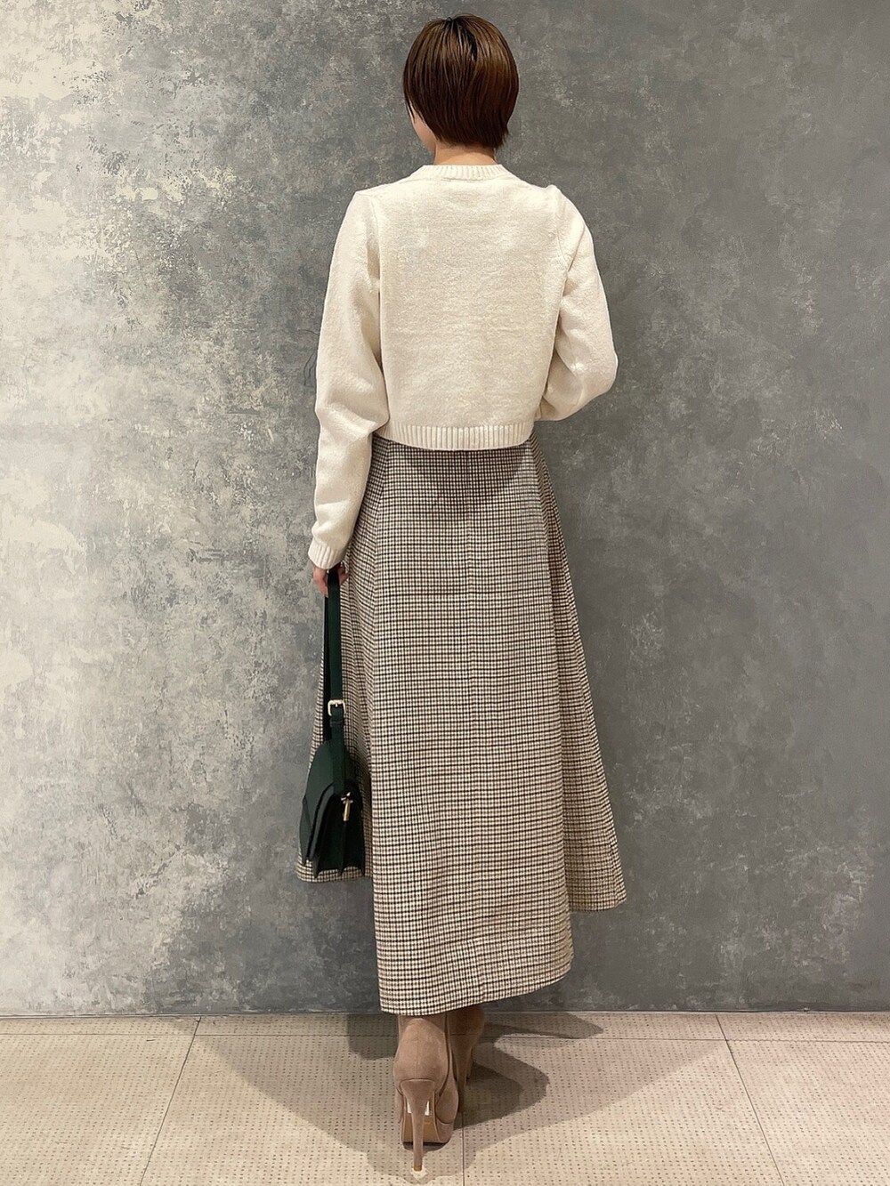 ホワイト系のカーディガン/ボレロ、グリーン系のショルダーバッグ、ベージュ系のブーツを着用したレディースの秋コーディネートの5枚目の写真