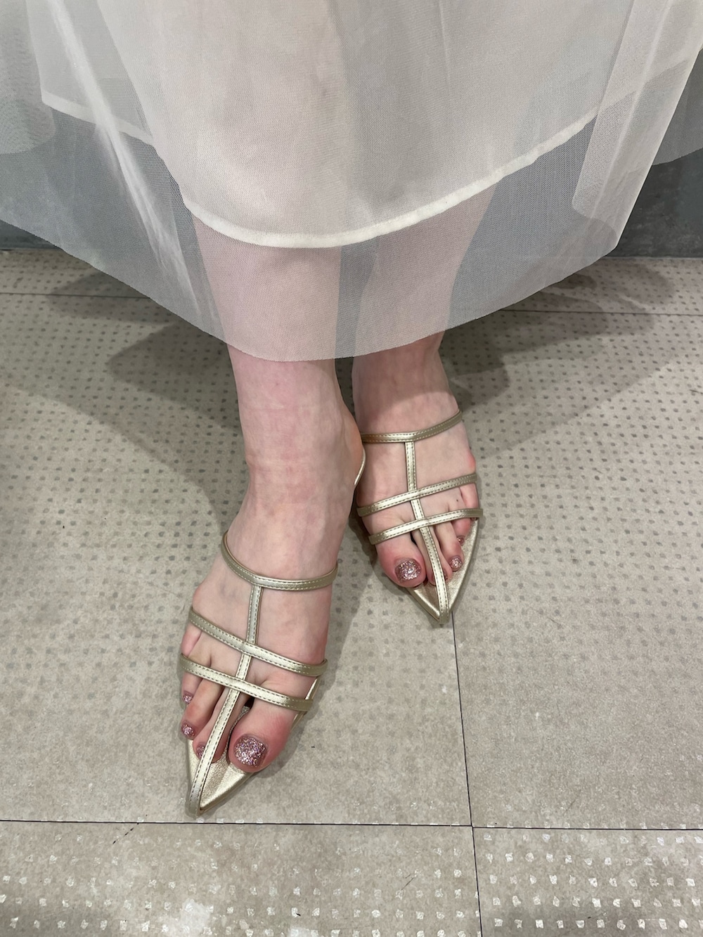 ブラック系のタンクトップ、ブラック系のデニムスカート、ゴールド系のサンダルを着用したレディースの春コーディネートの8枚目の写真