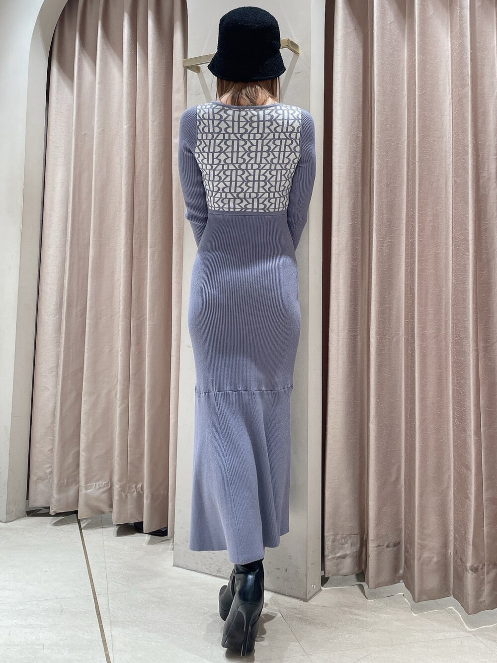 ブラック系のブーツ、ブルー系のワンピース、ブラック系のハットを着用したレディースの冬コーディネートの3枚目の写真