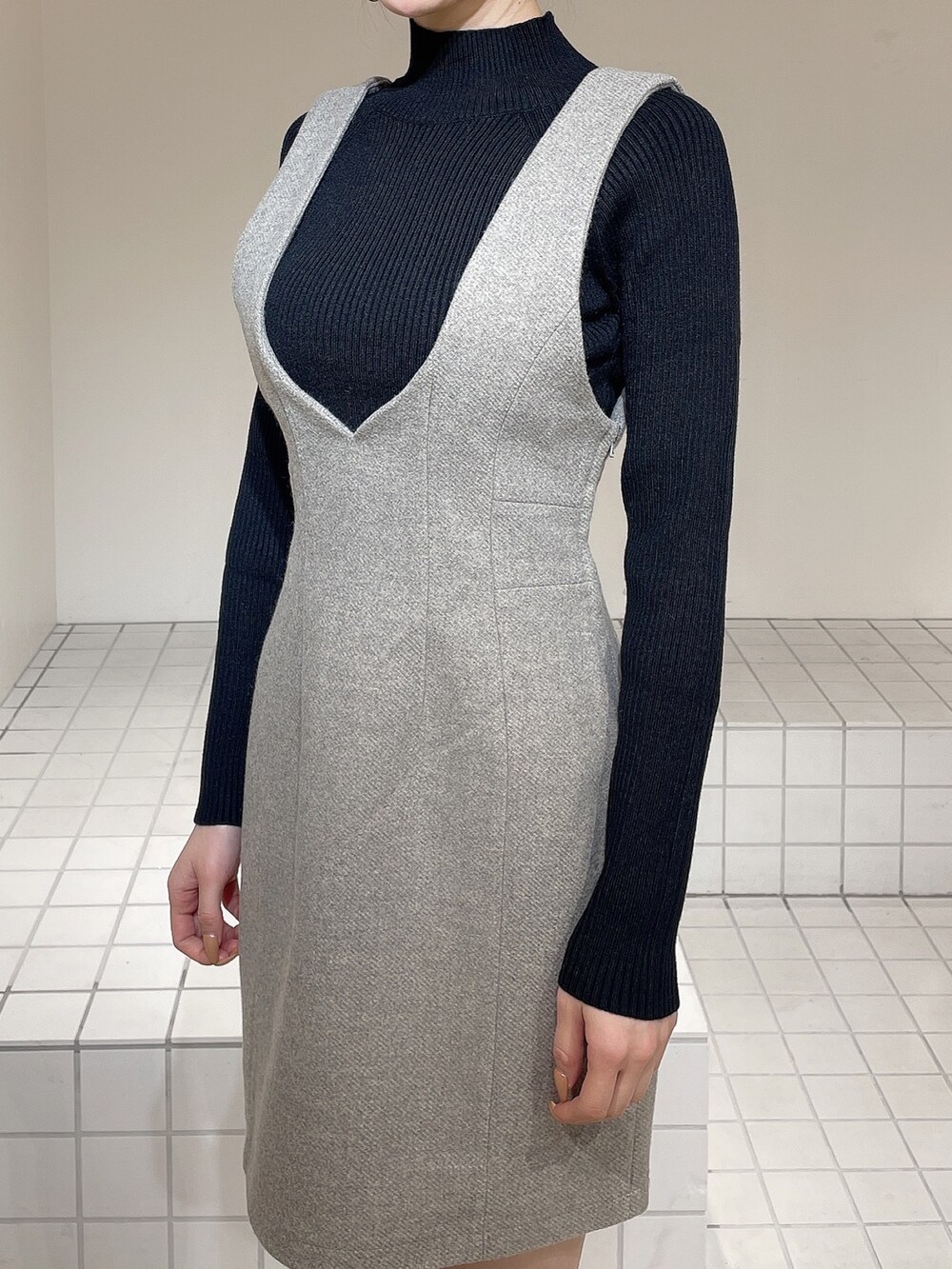 グレー系のその他アウター、グレー系のジャンパースカート、ブラック系のニット/セーターを着用したレディースの冬コーディネートの9枚目の写真