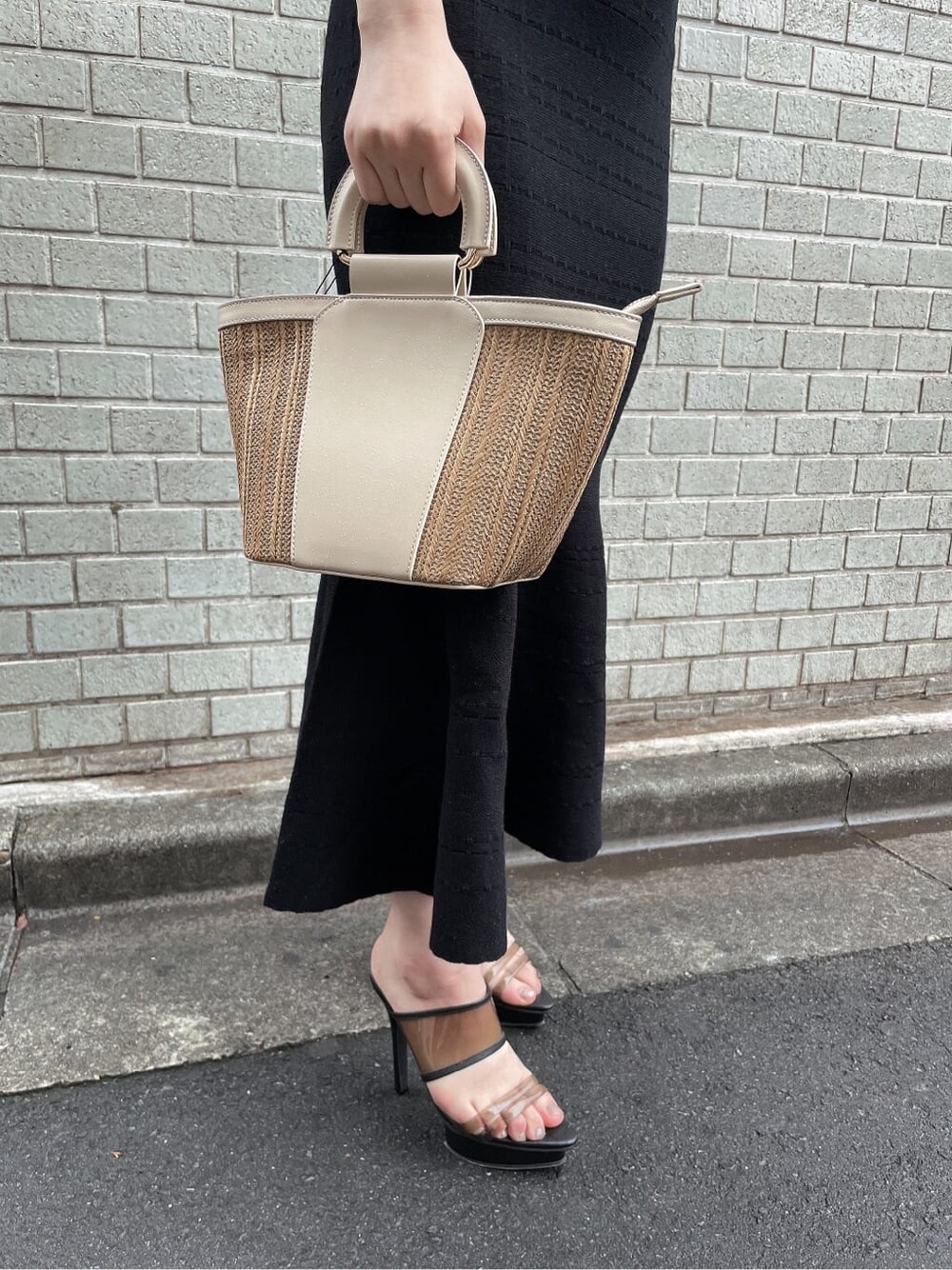 ブラック系のワンピース、ブラック系のサンダル、ベージュ系のハンドバッグを着用したレディースの夏コーディネートの9枚目の写真