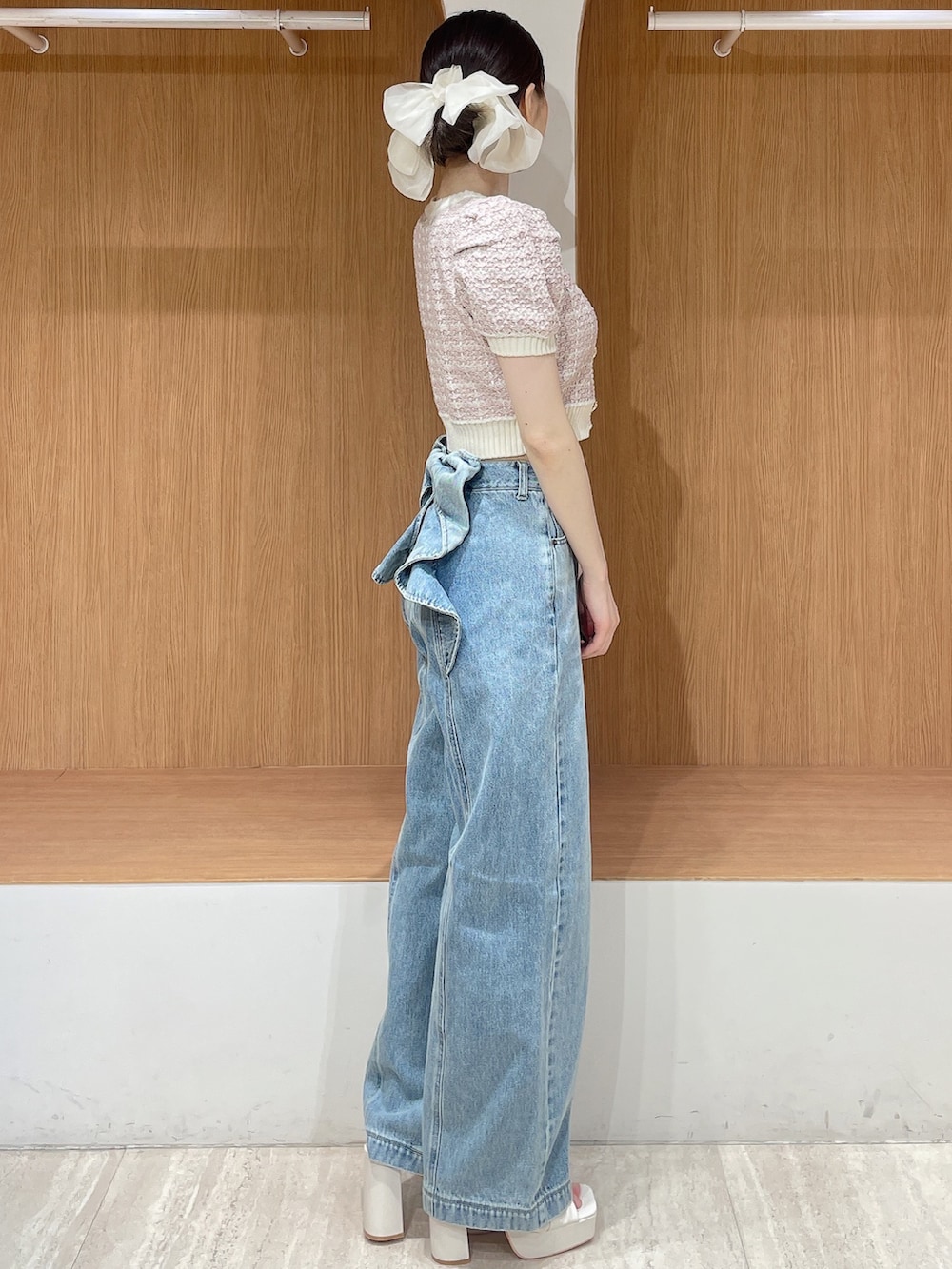 ピンク系のニット/セーター、ブルー系のデニムパンツ、ホワイト系のサンダルを着用したレディースの春コーディネートの3枚目の写真