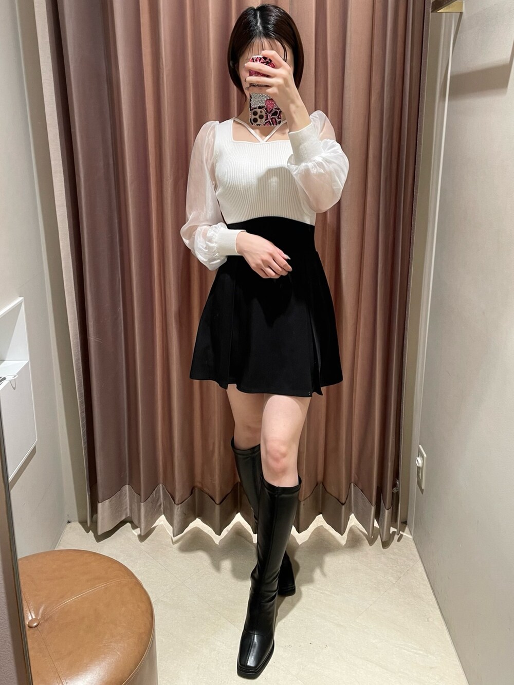 ホワイト系のニット/セーター、ブラック系のスカート、ブラック系のブーツを着用したレディースの冬コーディネートの2枚目の写真