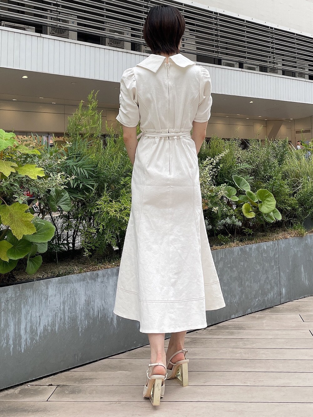 ホワイト系のワンピース、ホワイト系のハンドバッグ、ベージュ系のサンダルを着用したレディースの夏コーディネートの4枚目の写真