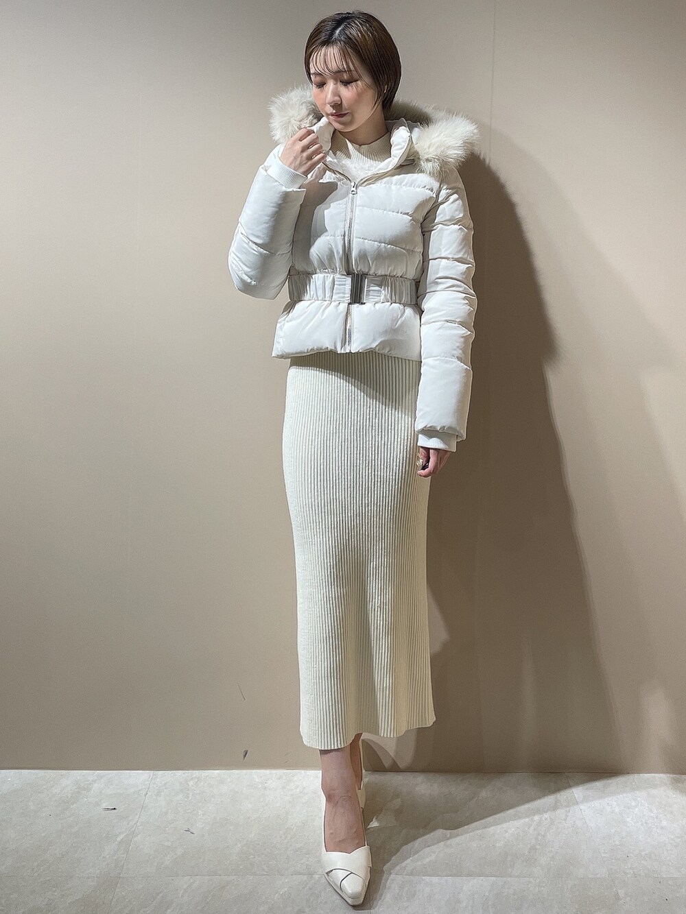 ホワイト系のワンピース、ホワイト系のダウンジャケット/コート、ホワイト系のパンプスを着用したレディースの秋コーディネートの6枚目の写真
