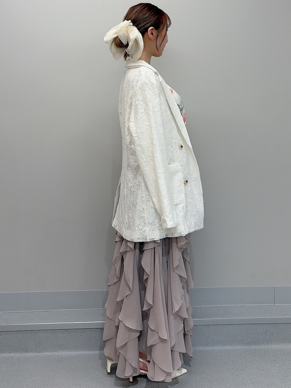 ホワイト系のテーラードジャケット、ホワイト系のシャツ/ブラウス、ベージュ系のスカートを着用したレディースの冬コーディネートの2枚目の写真