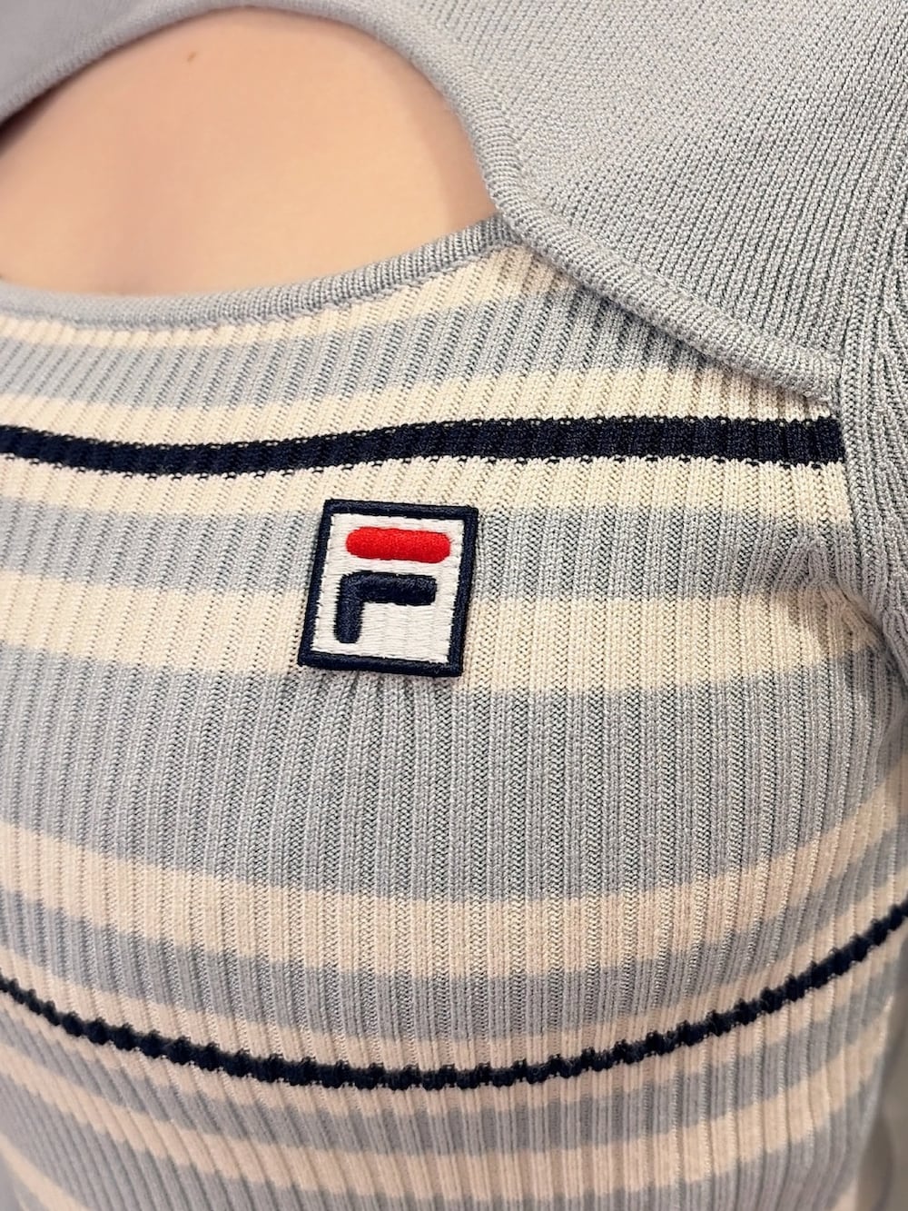 ホワイト系のブーツ、ブルー系のボストンバッグ、ブルー系のワンピースを着用したレディースの冬コーディネートの6枚目の写真