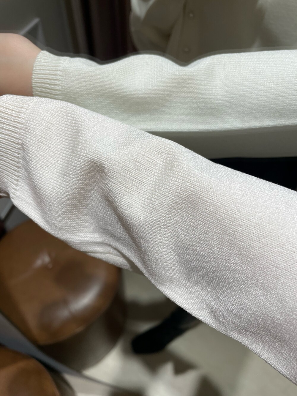 ホワイト系のカーディガン/ボレロ、ブラック系のスカート、ブラック系のブーツを着用したレディースの冬コーディネートの6枚目の写真