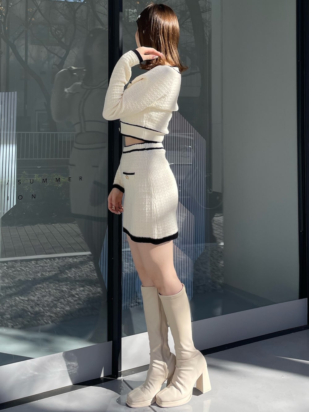 ホワイト系のダウンジャケット/コート、ホワイト系のニット/セーター、ホワイト系のスカートを着用したレディースの冬コーディネートの7枚目の写真