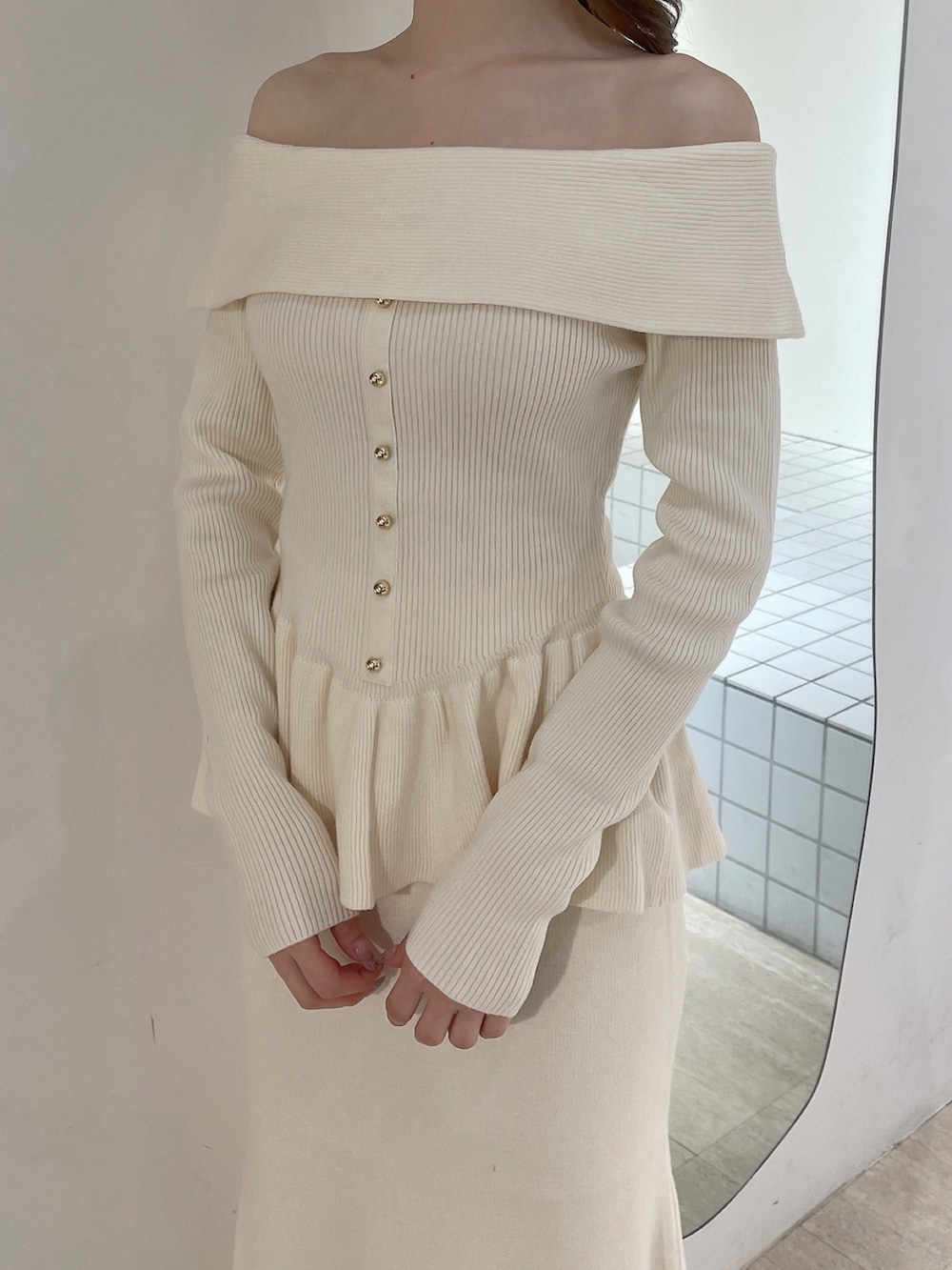 ホワイト系のニット/セーター、ホワイト系のスカート、ホワイト系のブーツを着用したレディースの冬コーディネートの5枚目の写真