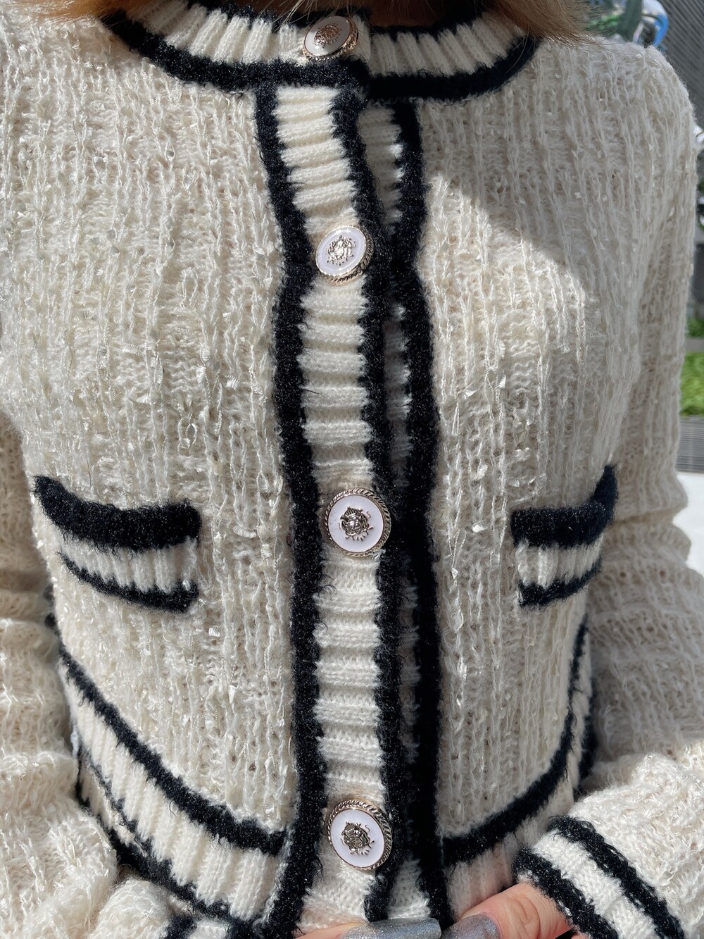 ホワイト系のカーディガン/ボレロ、ホワイト系のスカート、ブラック系のブーツを着用したレディースの秋コーディネートの7枚目の写真