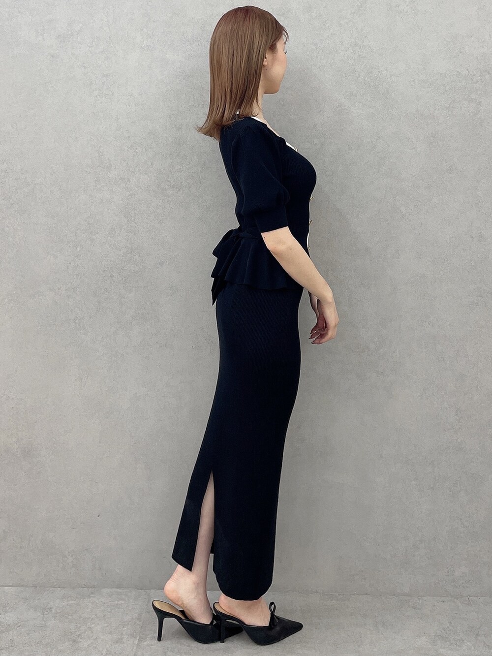 ブラック系のスカート、ブラック系のニット/セーター、ブラック系のパンプスを着用したレディースの冬コーディネートの3枚目の写真