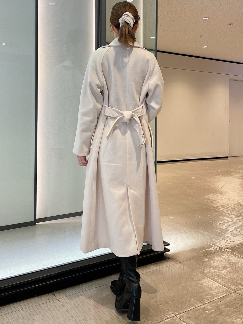 ホワイト系のその他アウター、ブラック系のワンピース、ブラック系のブーツを着用したレディースの冬コーディネートの3枚目の写真