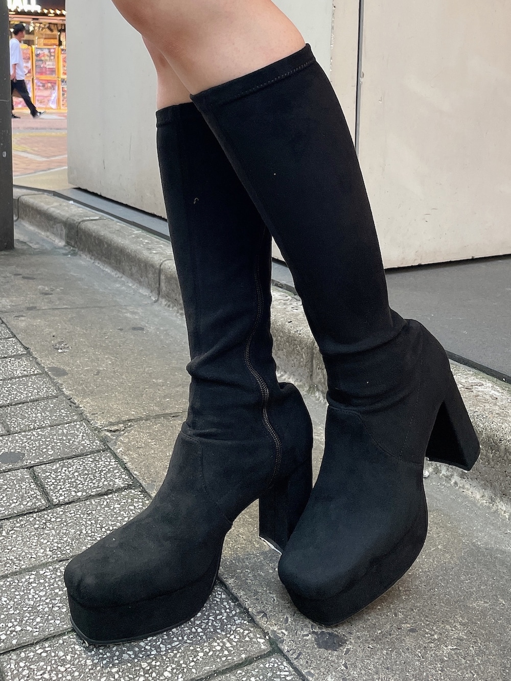 ブラック系のブーツ、ホワイト系のスカート、ブラック系のニット/セーターを着用したレディースの秋コーディネートの6枚目の写真