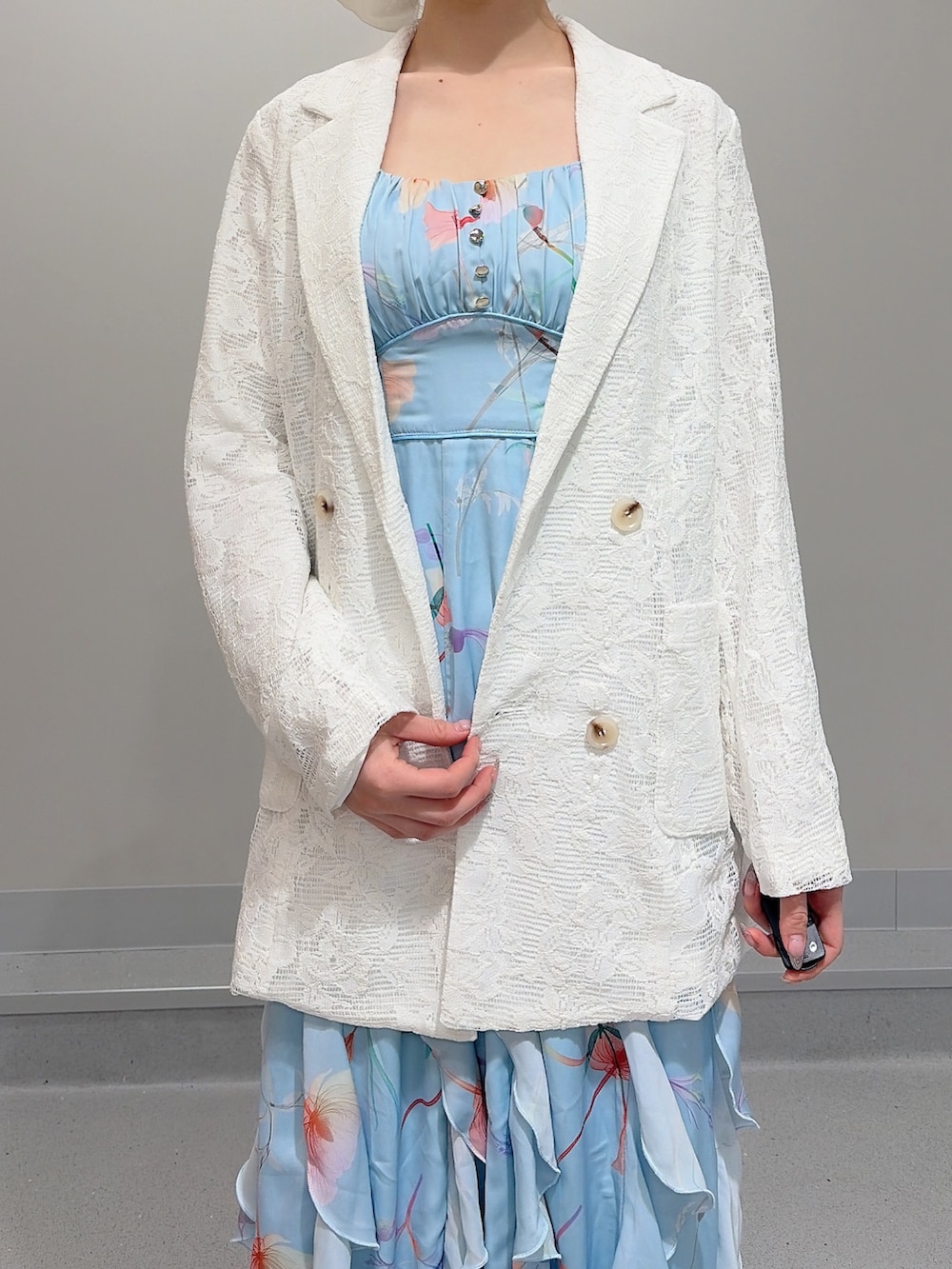 ホワイト系のテーラードジャケット、ブルー系のワンピース、ホワイト系のパンプスを着用したレディースの冬コーディネートの5枚目の写真