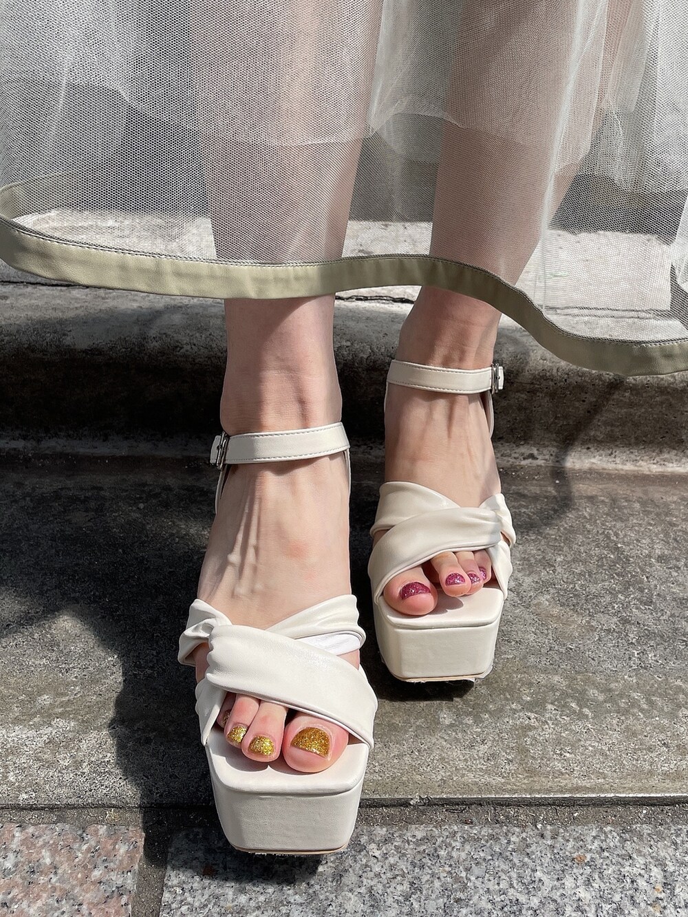 ホワイト系のサンダル、ブルー系のニット/セーター、ブラック系のスカートを着用したレディースの夏コーディネートの8枚目の写真