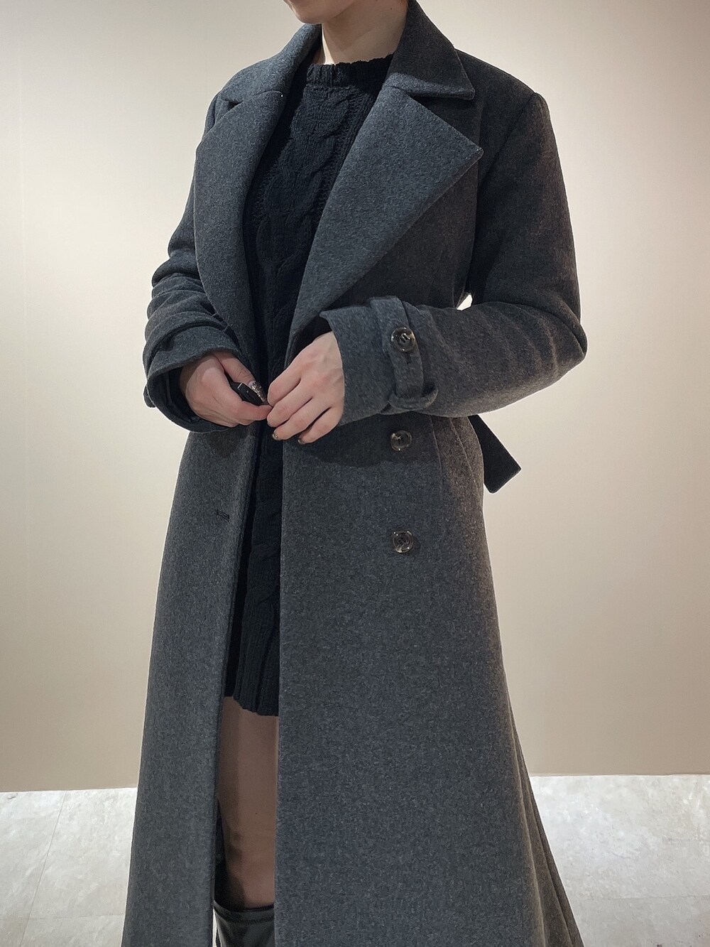 ブラック系のニット/セーター、グレー系のチェスターコート、ブラック系のブーツを着用したレディースの秋コーディネートの9枚目の写真