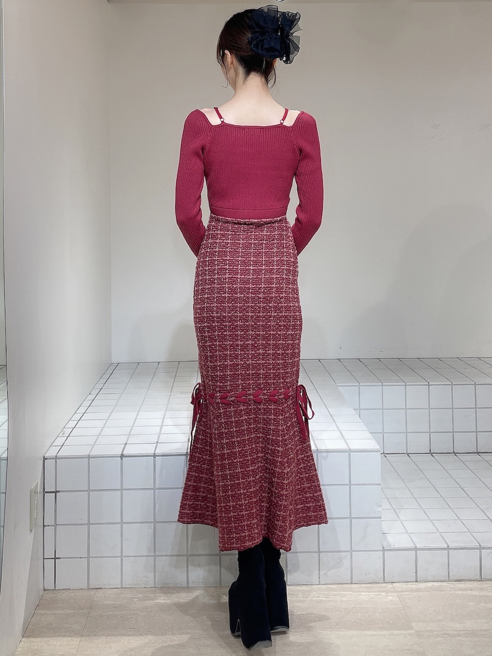 レッド系のワンピース、ブラック系のブーツ、ブラック系のバレッタ/ヘアクリップを着用したレディースの冬コーディネートの3枚目の写真