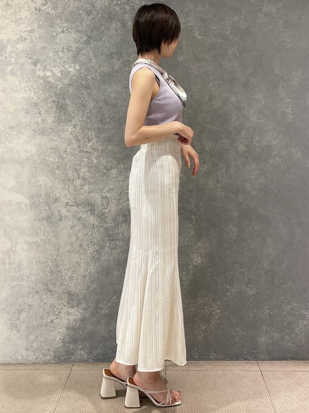 ホワイト系のサンダル、ホワイト系のスカート、パープル系のタンクトップを着用したレディースの夏コーディネートの2枚目の写真