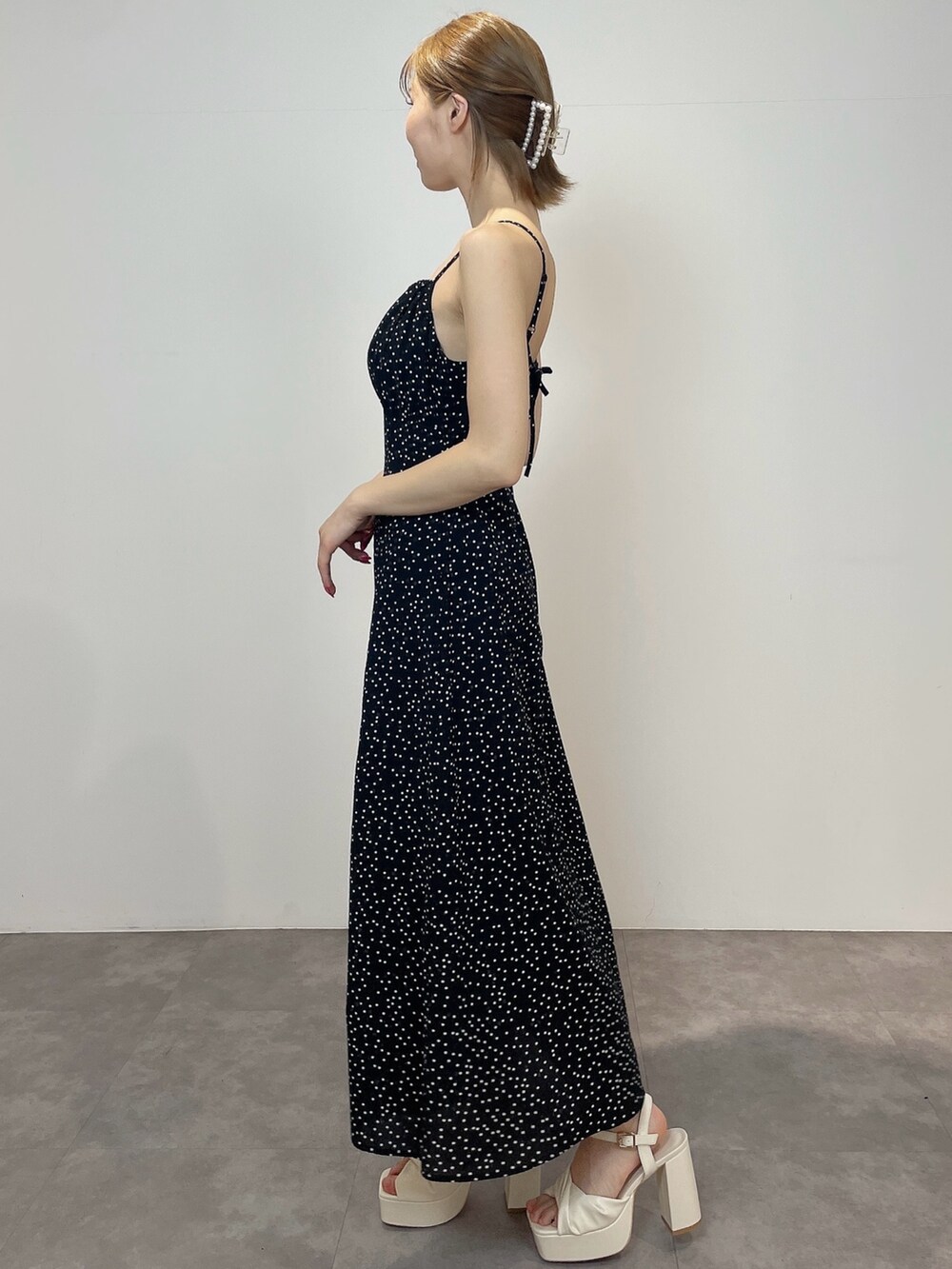 ブラック系のワンピース、ホワイト系のサンダルを着用したレディースの冬コーディネートの4枚目の写真