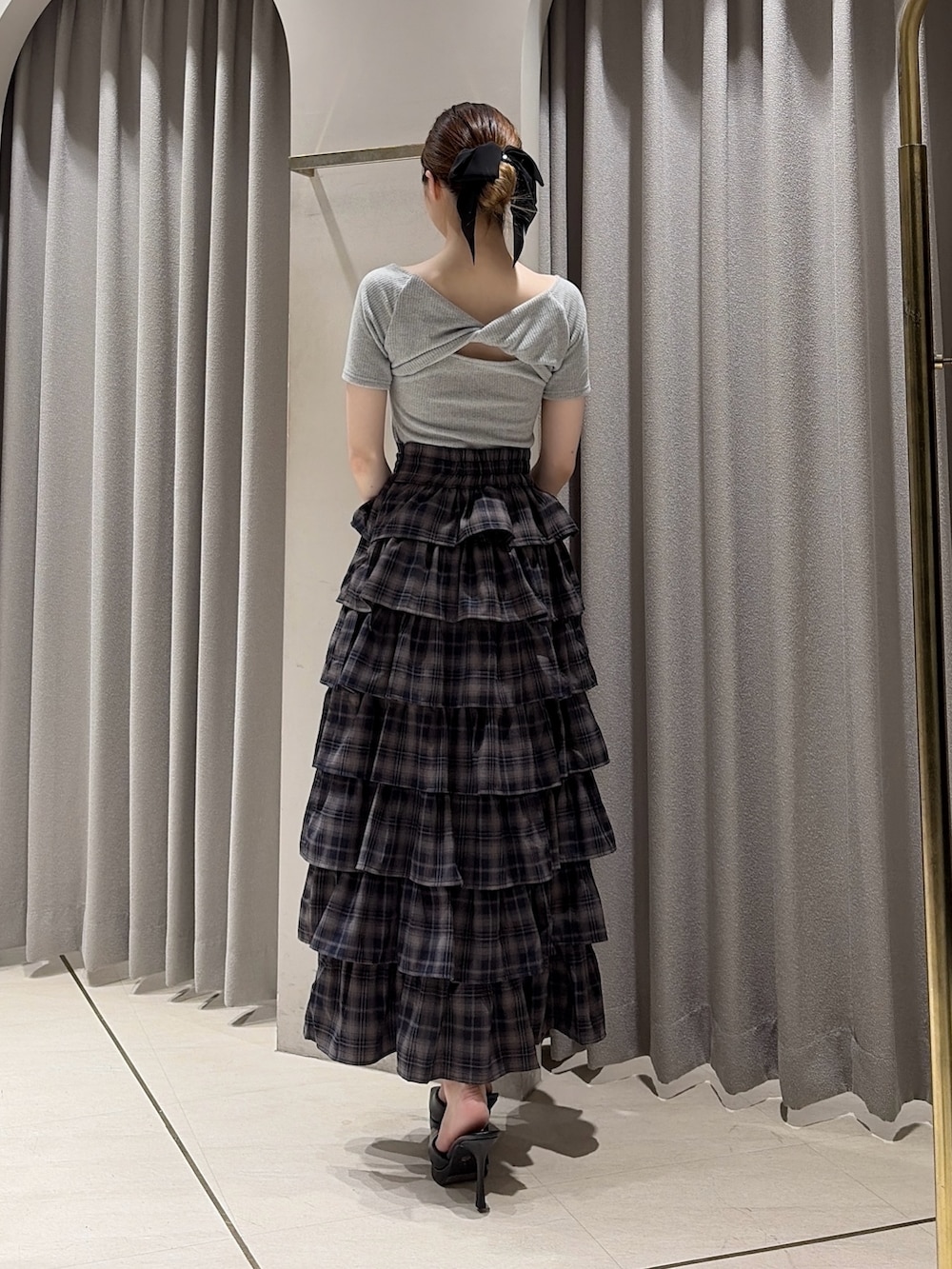 グレー系のTシャツ/カットソー、グレー系のスカート、ブラック系のパンプスを着用したレディースの夏コーディネートの5枚目の写真