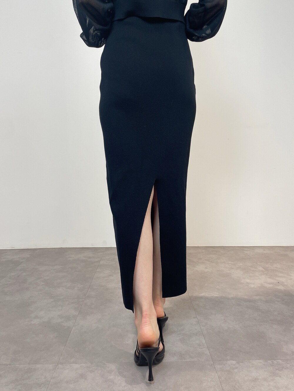 ブラック系のワンピース、ブラック系のパンプスを着用したレディースの冬コーディネートの8枚目の写真