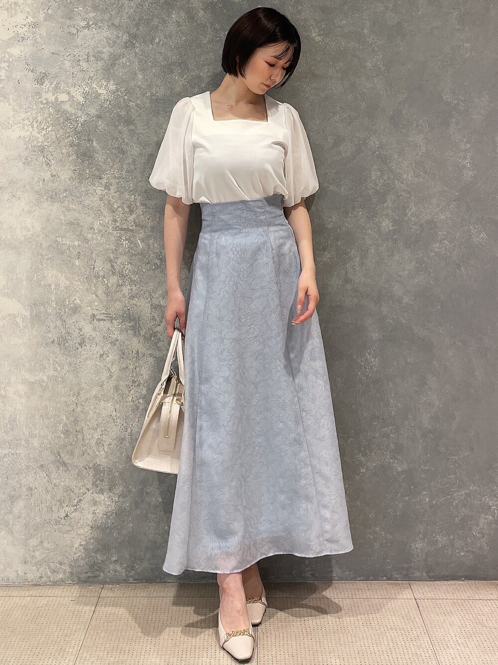 ホワイト系のサンダル、ブルー系のスカート、ホワイト系のTシャツ/カットソーを着用したレディースの春コーディネートの2枚目の写真