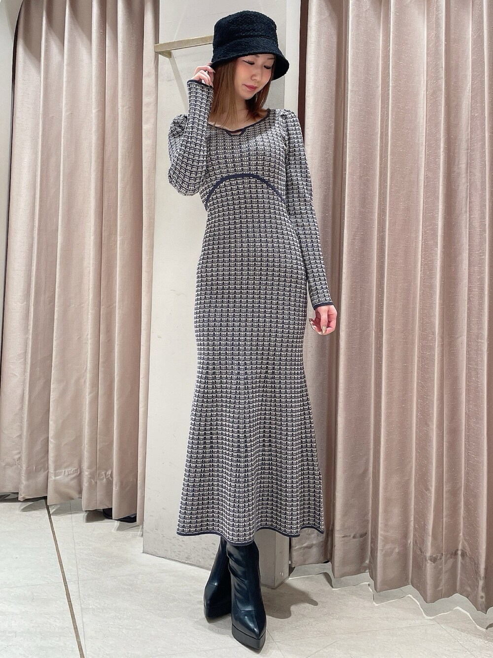 ブラック系のダウンジャケット/コート、ブルー系のワンピース、ブラック系のブーツを着用したレディースの冬コーディネートの4枚目の写真