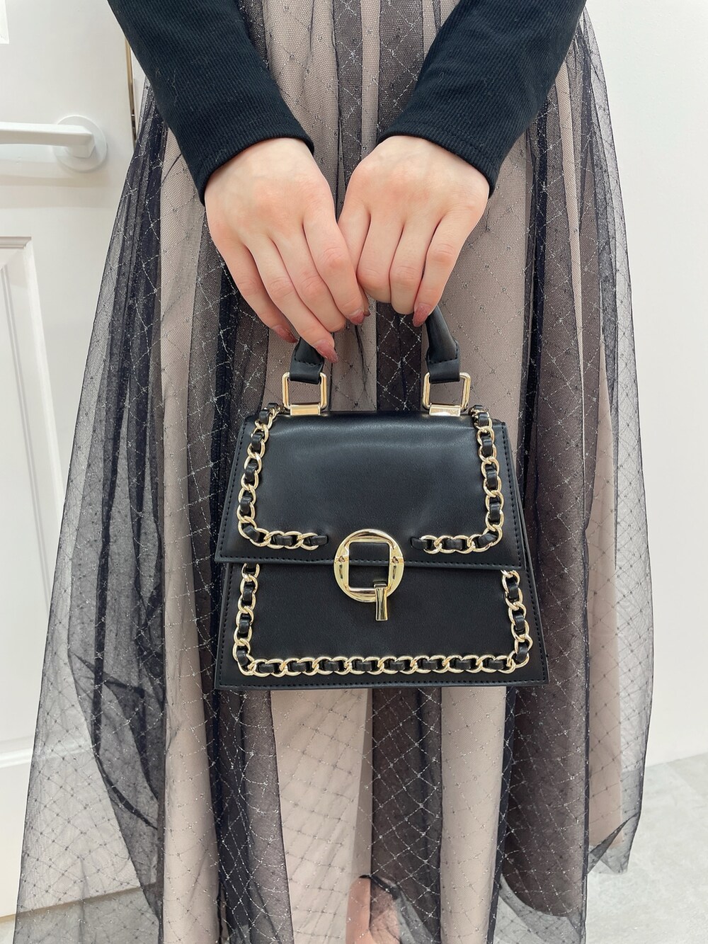 ブラック系のワンピース、ブラック系のハンドバッグ、ブラック系のパンプスを着用したレディースの冬コーディネートの9枚目の写真