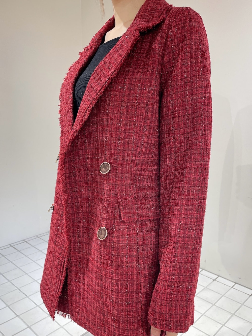 レッド系のテーラードジャケット、レッド系のスカート、ブラック系のニット/セーターを着用したレディースの秋コーディネートの7枚目の写真