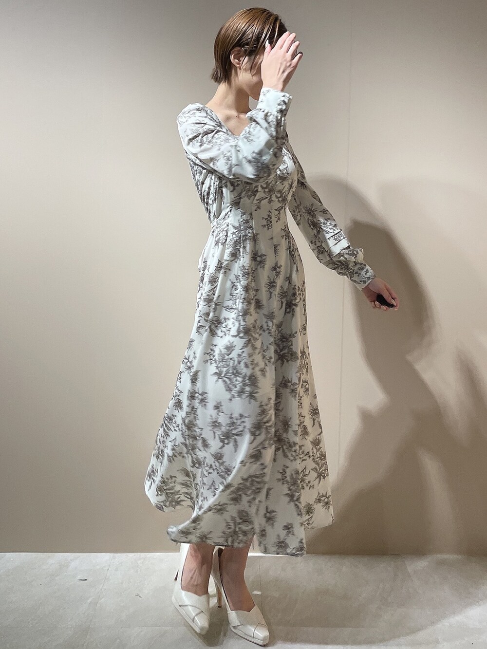 ホワイト系のダウンジャケット/コート、ホワイト系のパンプス、ベージュ系のワンピースを着用したレディースの秋コーディネートの7枚目の写真