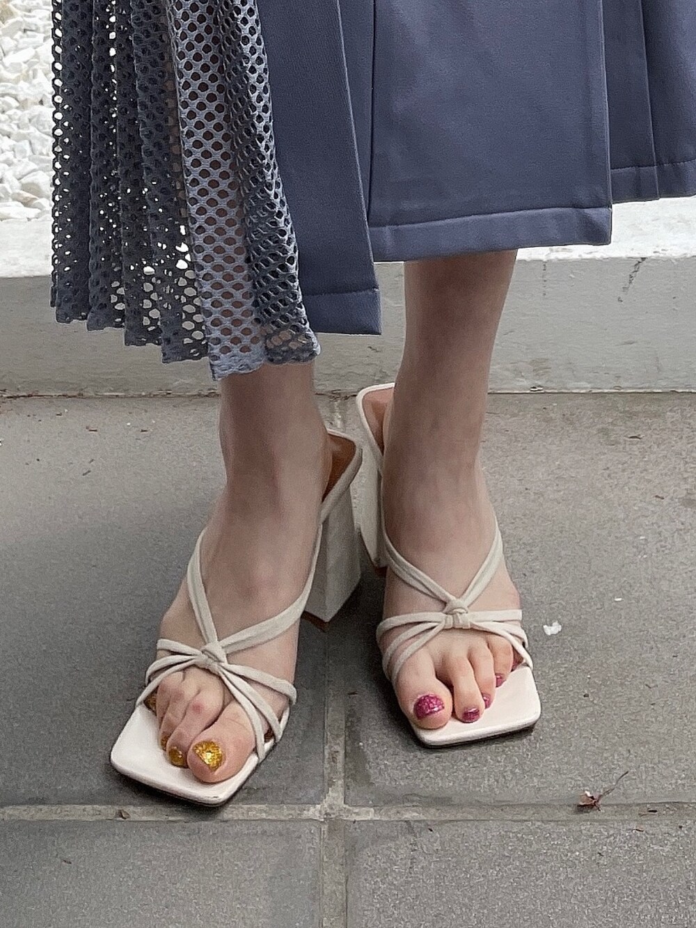 ホワイト系のサンダル、ホワイト系のスカート、ブラック系のニット/セーターを着用したレディースの春コーディネートの9枚目の写真