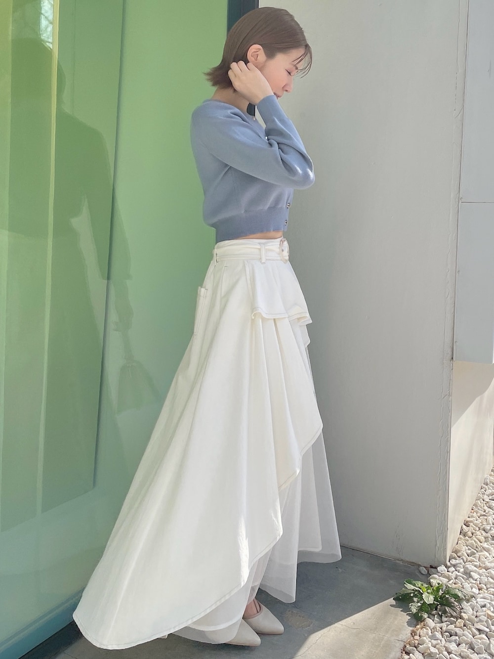 ブルー系のカーディガン/ボレロ、ホワイト系のデニムスカート、ホワイト系のハンドバッグを着用したレディースの春コーディネートの2枚目の写真