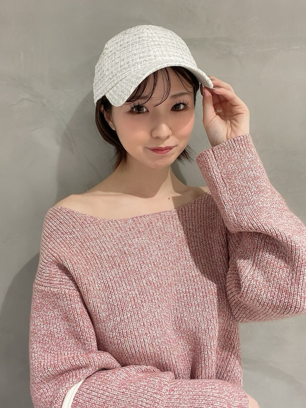 ピンク系のニット/セーター、ホワイト系のハンドバッグ、ブルー系のデニムパンツを着用したレディースの冬コーディネートの9枚目の写真