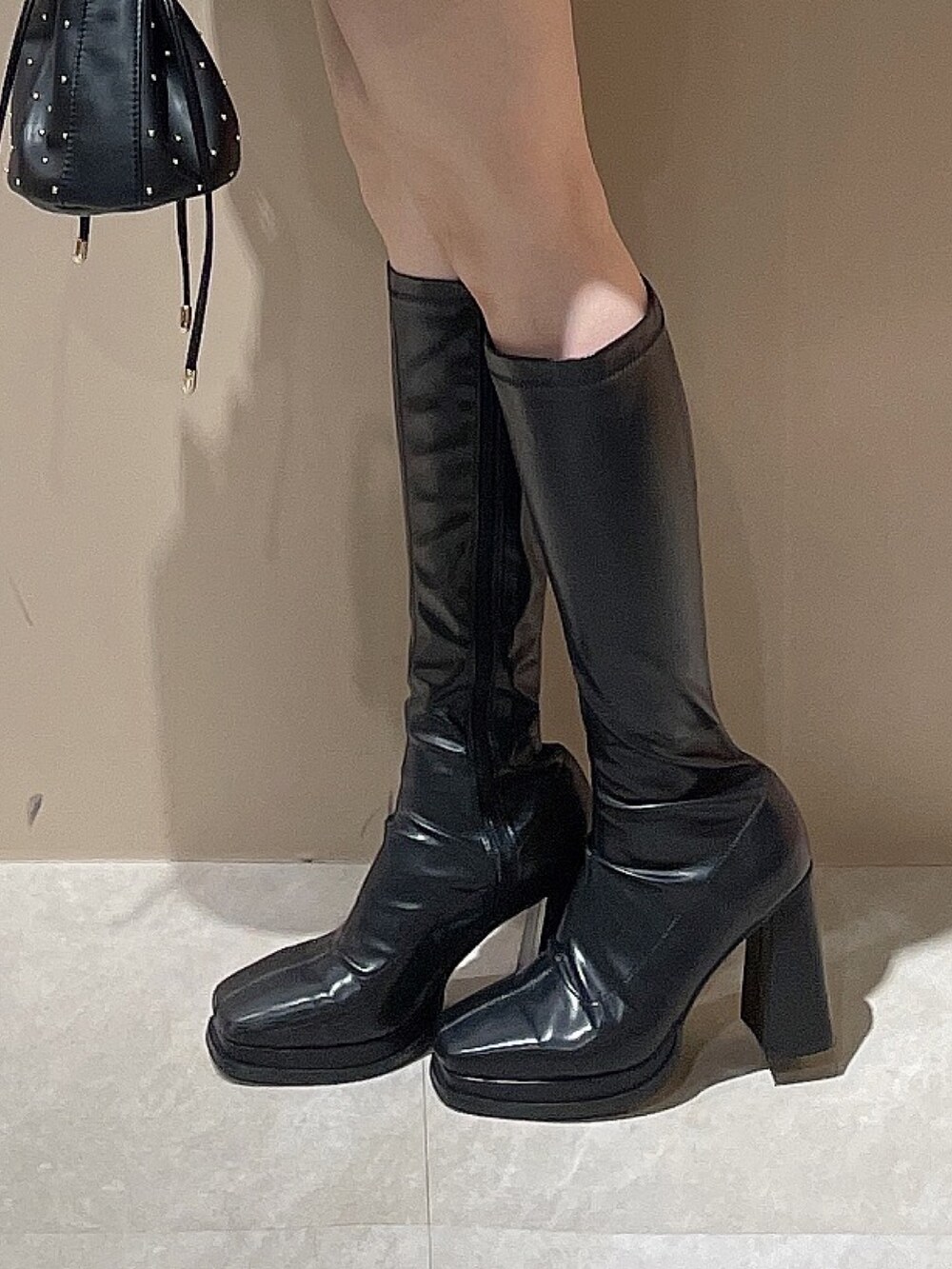 ブラック系のハンドバッグ、ブラック系のカーディガン/ボレロ、ホワイト系のスカートを着用したレディースの秋コーディネートの8枚目の写真