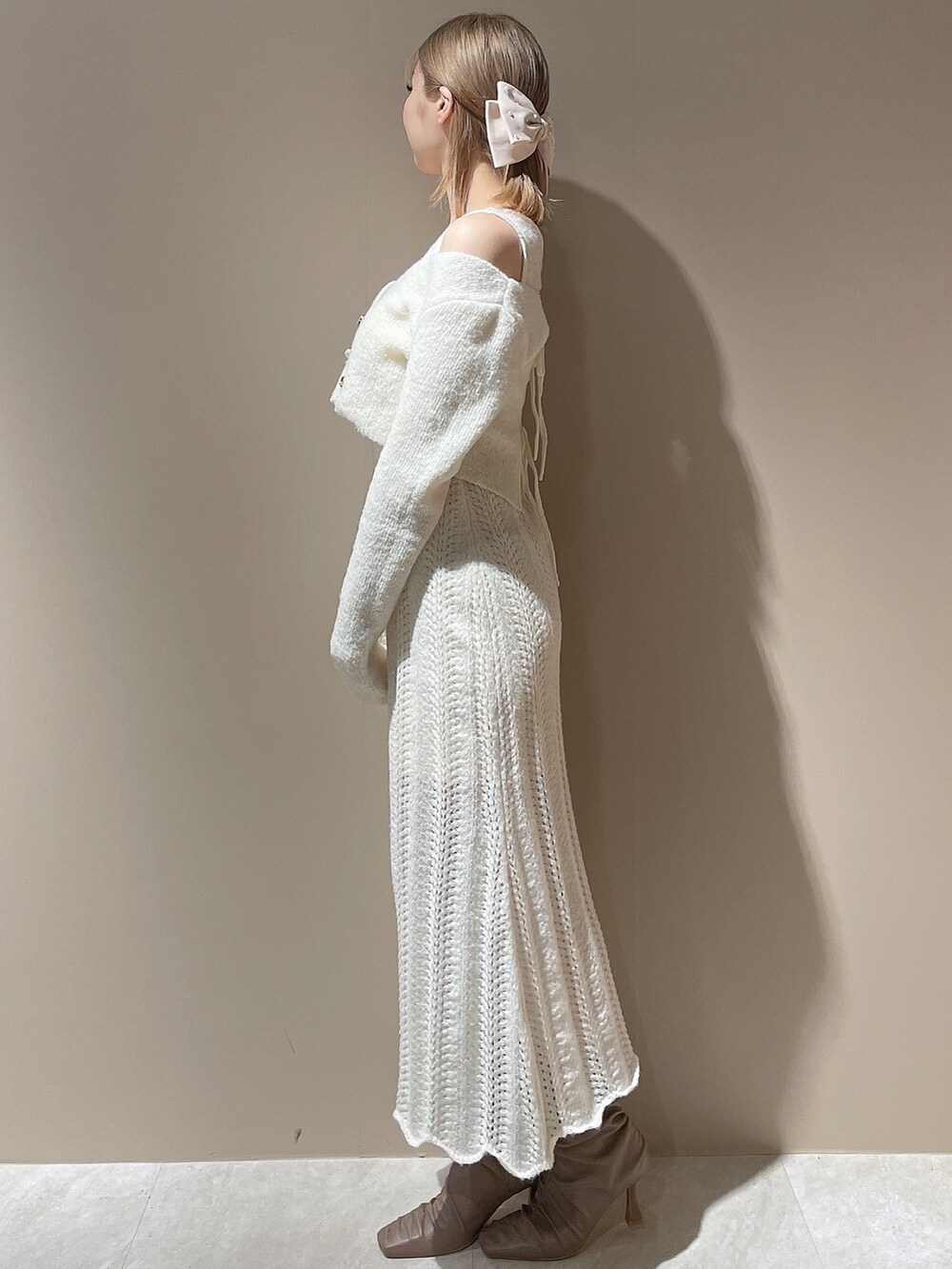 ホワイト系のブルゾン、ホワイト系のワンピース、ベージュ系のブーツを着用したレディースの秋コーディネートの5枚目の写真