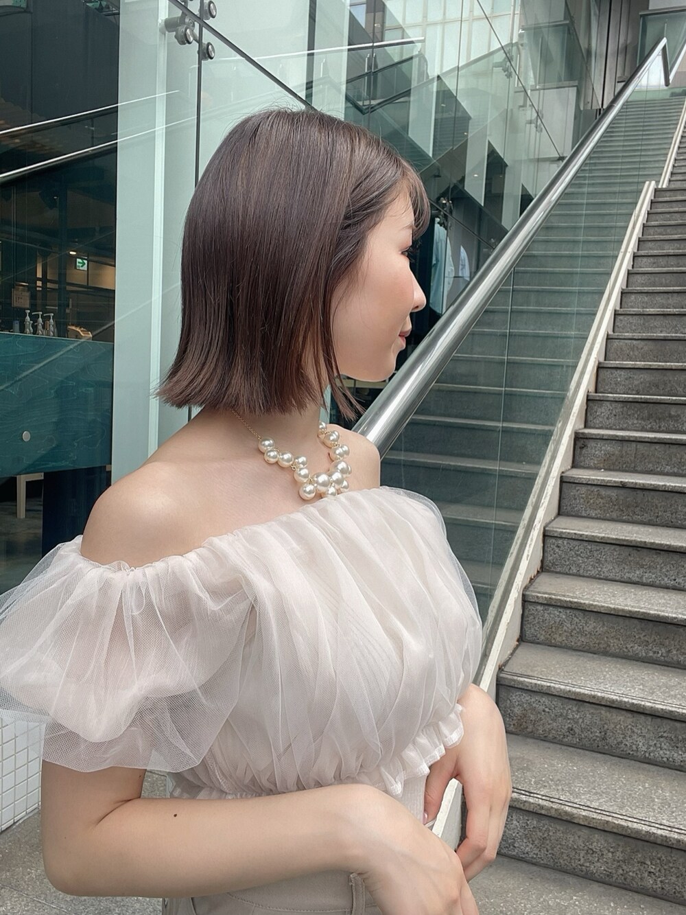 ホワイト系のシャツ/ブラウス、ベージュ系のスカート、ホワイト系のサンダルを着用したレディースの春コーディネートの5枚目の写真