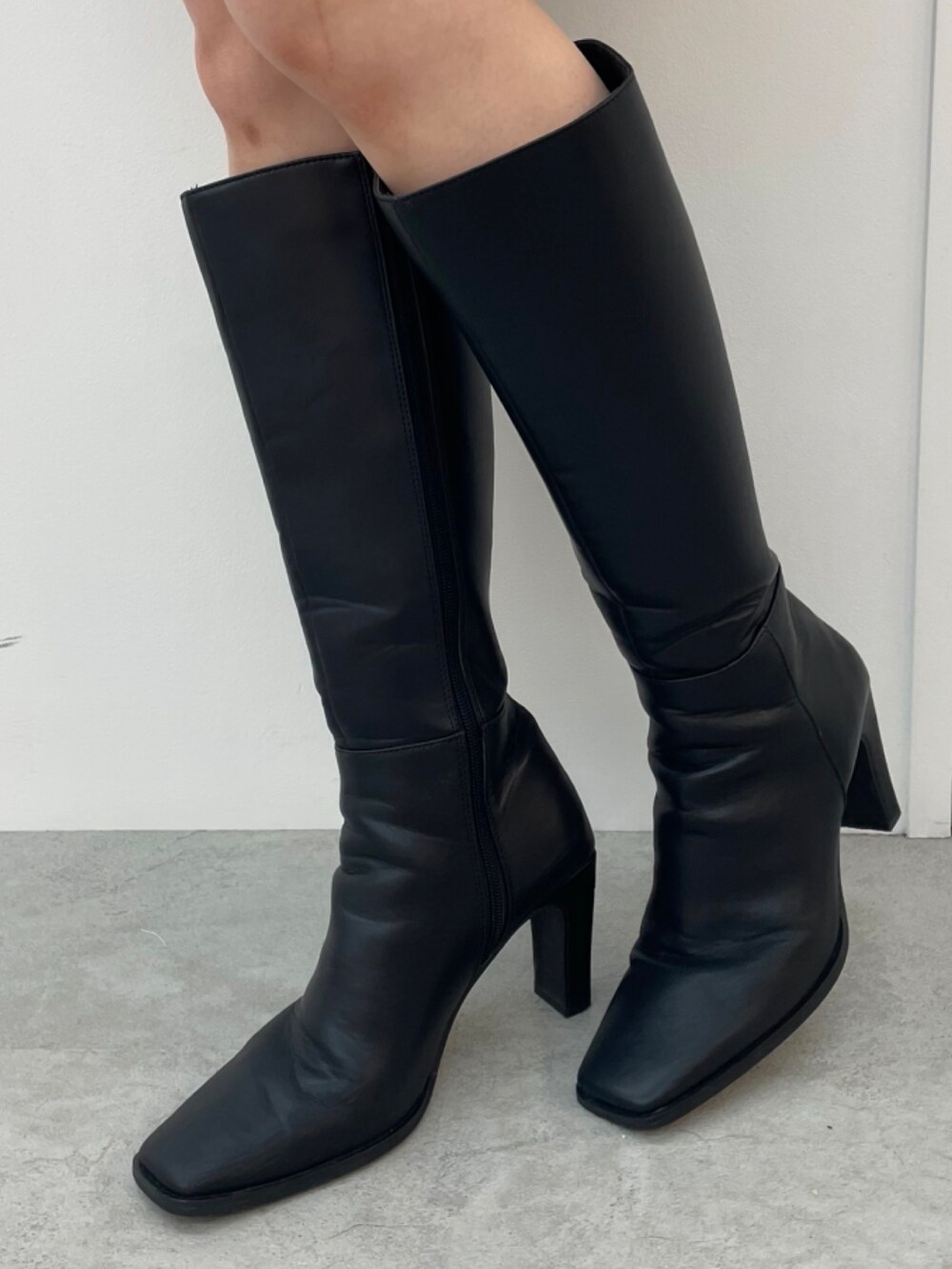 ブルー系のニット/セーター、グレー系のスカート、ブラック系のブーツを着用したレディースの秋コーディネートの5枚目の写真