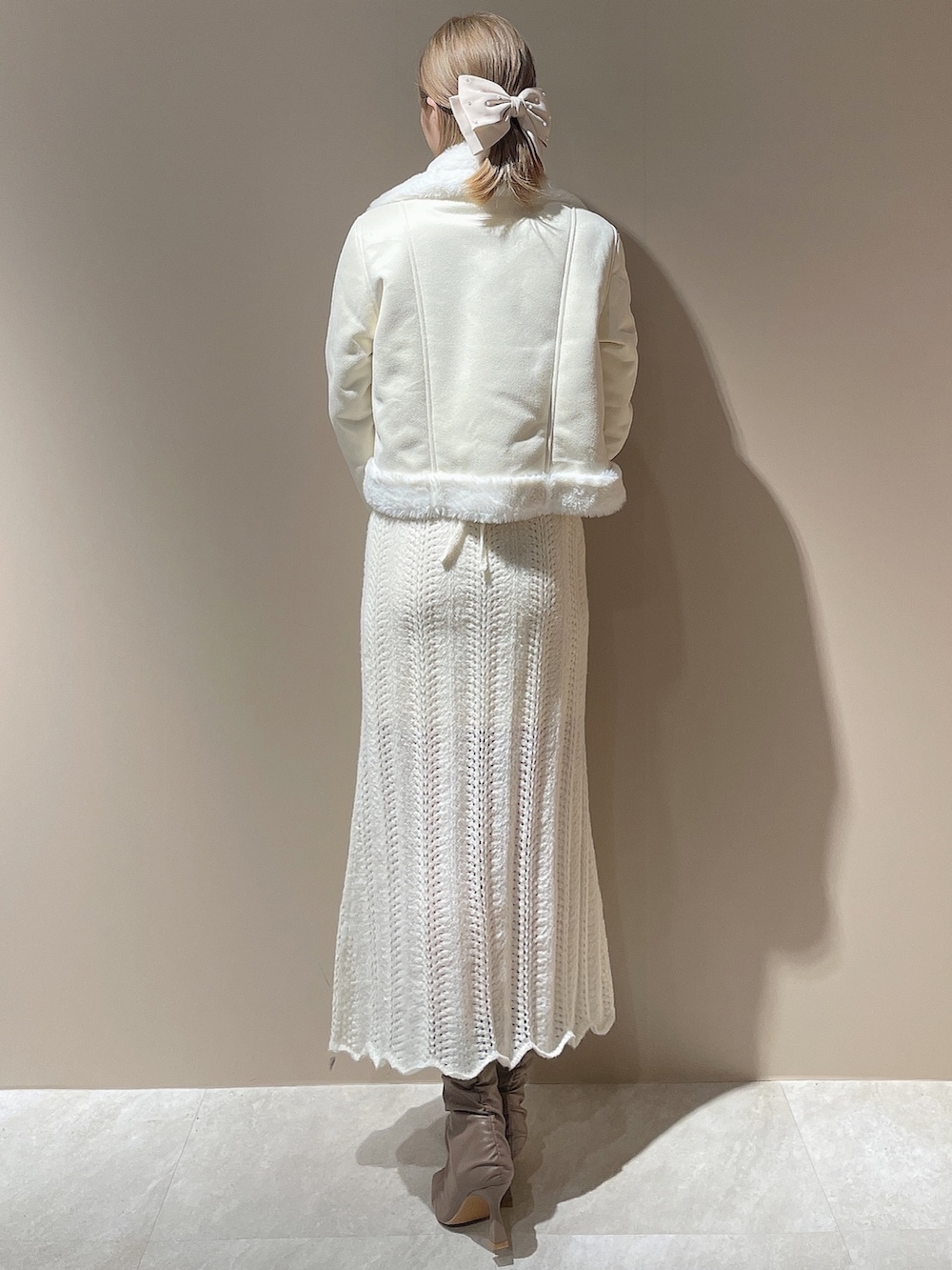 ホワイト系のブルゾン、ホワイト系のワンピース、ベージュ系のブーツを着用したレディースの秋コーディネートの3枚目の写真